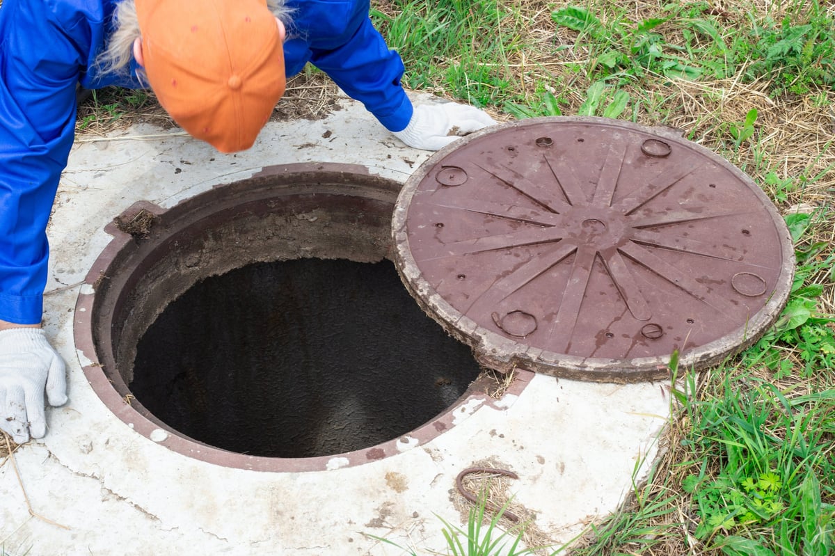 the plumber leaned over the concrete well. Control and maintenance of septic wells.